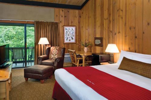 a hotel room with a bed and a chair and a desk at Shawnee Lodge & Conference Center in Camp Oyo