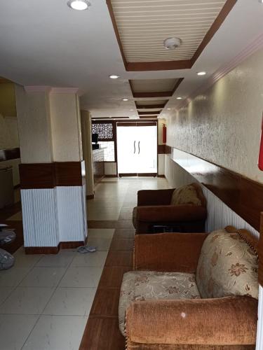a living room with couches and a couch in a room at Stay Inn Guest House in Karachi