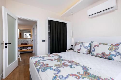 a bedroom with a white bed and white walls at Ece Marina Suit in Fethiye