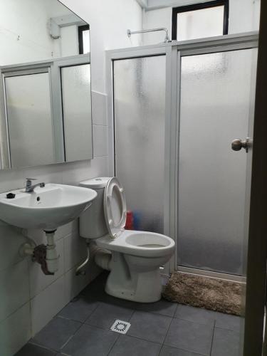 a bathroom with a toilet and a sink and a shower at A29 Benoni Garden Suites in Papar
