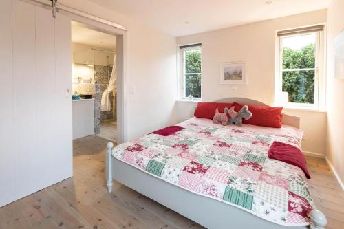 a bedroom with a bed with a red and white quilt at Ferienhaus Mitteldeich in Hellschen-Heringsand-Unterschaar