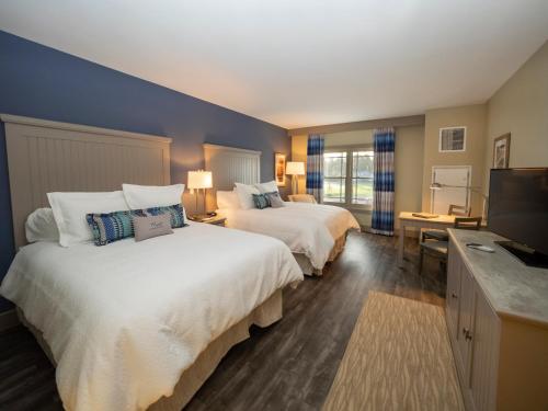 a hotel room with two beds and a flat screen tv at Chautauqua Harbor Hotel - Jamestown in Celoron