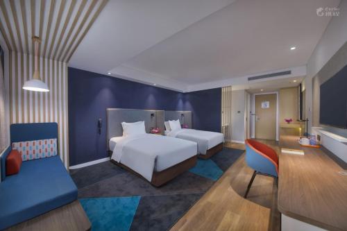 乌鲁木齐Holiday Inn Express Urumqi Station by IHG的一间卧室，有两张床和一面蓝色的墙