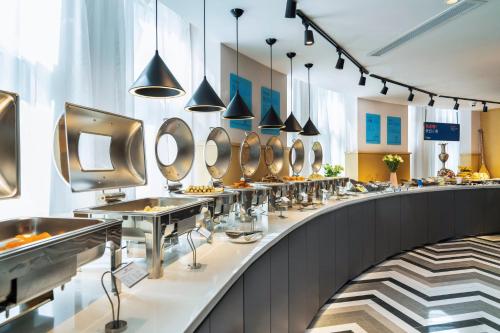 a buffet line with sinks and mirrors at Holiday Inn Express Urumqi Station by IHG in Ürümqi
