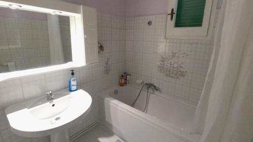 a bathroom with a sink and a bath tub and a sink at Amalia's House in Liapades