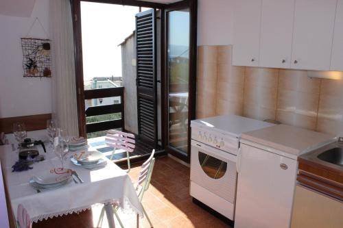 a kitchen with a table and a white stove top oven at Apartments Petrada in Omiš