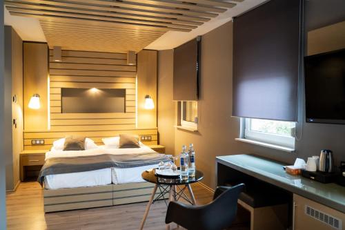 ein Schlafzimmer mit einem Bett und einem Schreibtisch mit einem Tisch von sidx sidx sidx in der Unterkunft Zum grünen Baum Hotel Frankfurt Airport in Kelsterbach