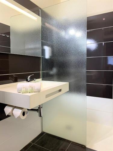 a bathroom with a sink and a mirror at Hôtel Grand Confort Le Moulin Rouge in Terrasson-Lavilledieu