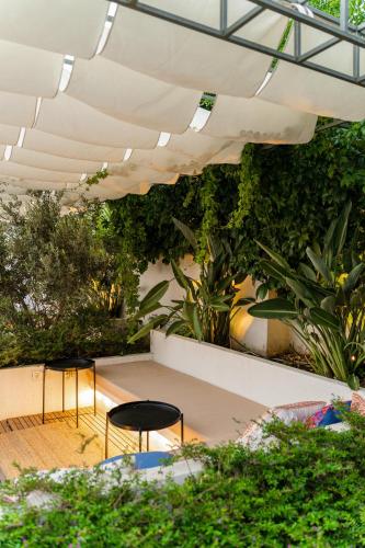 a garden with plants and chairs in a building at Torbahan Hotel in Torba