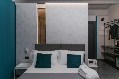 a bedroom with a bed with green and white pillows at WeLive in Carpi