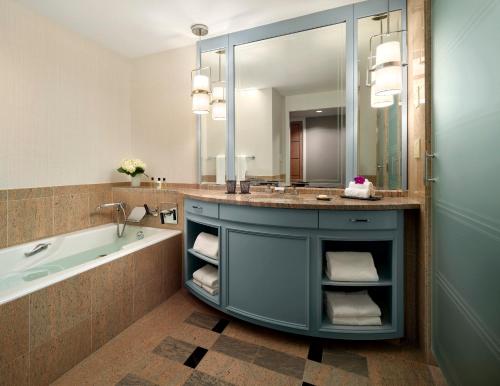 a bathroom with a sink and a tub and a mirror at Mandarin Oriental Boston in Boston