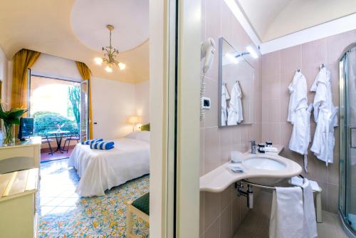 un bagno con lavandino e un letto in una camera di Hotel San Lorenzo Thermal Spa a Ischia