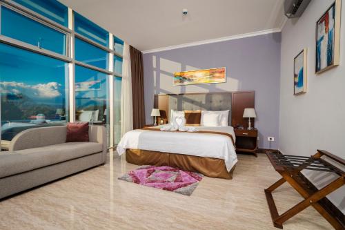 een slaapkamer met een bed en een bank bij Hotel City Plaza & Suites in David