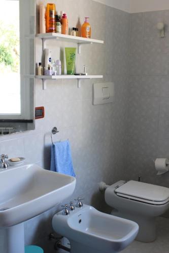 a white bathroom with a sink and a toilet at villa panoramica in Lavagna