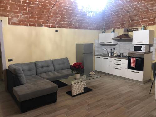 Una sala de estar con un sofá y una cocina. en Residenza Nikol, en Casale Monferrato