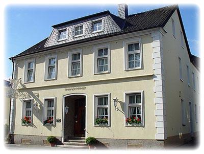 a white house with a black roof at Hotel-Restaurant Kranefoer in Waltrop
