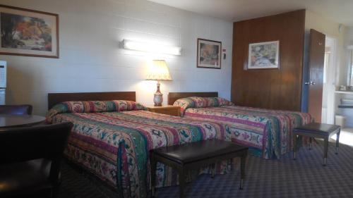una habitación de hotel con 2 camas y una lámpara en Budget Host Exit 254 Inn, en Loveland