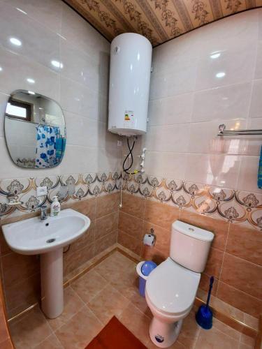 a bathroom with a sink and a toilet and a mirror at Зона отдых APACHI в горах ЧИМГАН in Chimgan