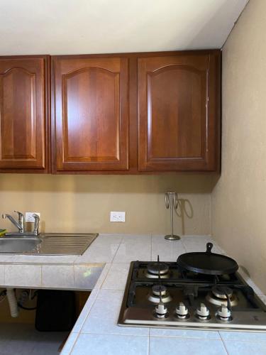 a kitchen with a stove top with wooden cabinets at Cabaña el Pino 1 in Creel