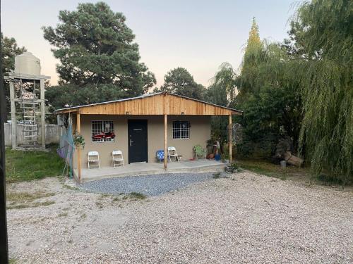 a small house with two chairs and a porch at Cabaña el Pino 1 in Creel