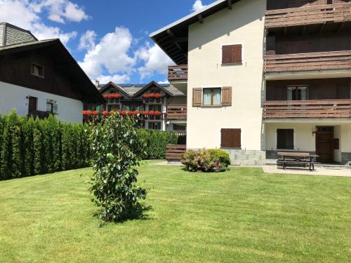 a large white building with a green yard at Casa Coltura in Bormio