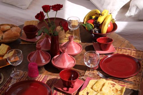 a table topped with red dishes and a bunch of food at Riad O2 in Marrakech
