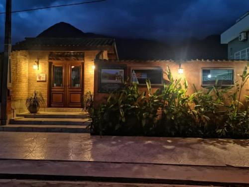 a house with a front door at night at Chalés Ki Aconchego -Condominio Morada da Praia - Boracéia in Boracéia