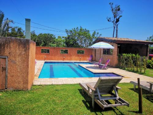 a swimming pool in the yard of a house at Chalés Ki Aconchego -Condominio Morada da Praia - Boracéia in Boracéia