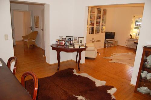 a living room with a table and a couch at Haus Rothenstein, ruhige FeWo, ca. 10 min. zu Messe und Flughafen in Meerbusch