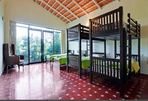 sypialnia z 2 łóżkami piętrowymi i salonem w obiekcie Aakriti Homestay w mieście Chikmagalur