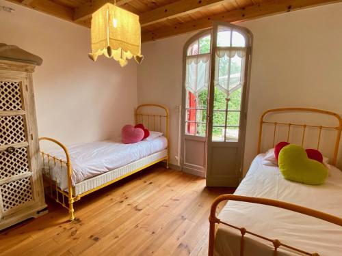 deux lits dans une chambre avec deux fenêtres dans l'établissement Idyllic Chalet right near the dunes in Cap Ferret, à Lège-Cap-Ferret