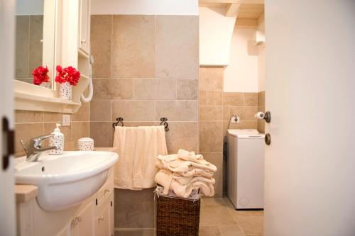 een badkamer met een wastafel, een toilet en een handdoek bij Masseria Bianca di Puglia in Monopoli