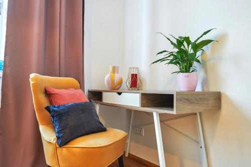 a desk with a chair with a pillow and a plant at Residence Rybna 9- Old Town in Prague