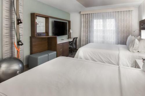 a hotel room with two beds and a television at EVEN Hotel Chicago - Tinley Park - Convention Center, an IHG Hotel in Tinley Park
