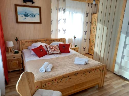 a bedroom with a wooden bed with towels on it at Willa Polka in Bukowina Tatrzańska