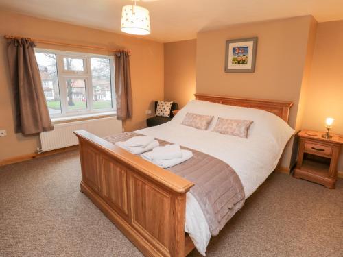 a bedroom with a large bed and a window at Barnaby Cottage in Yarm