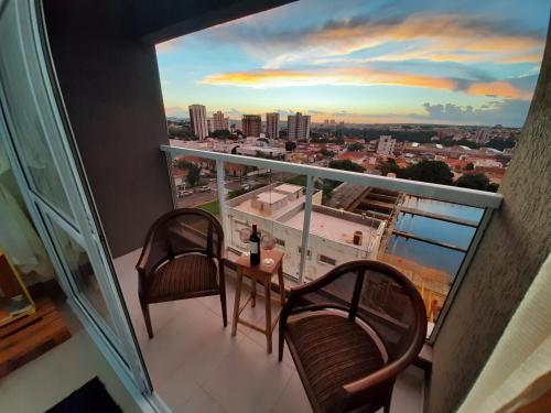 a balcony with two chairs and a table with a view at VIKINGS- Alto Padrão, Apto Rústico com conforto,Wifi e vista incrivel máx 4 in São Carlos