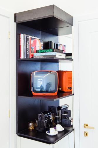 an orange tv is sitting on a shelf at Hotel Milu Florence in Florence