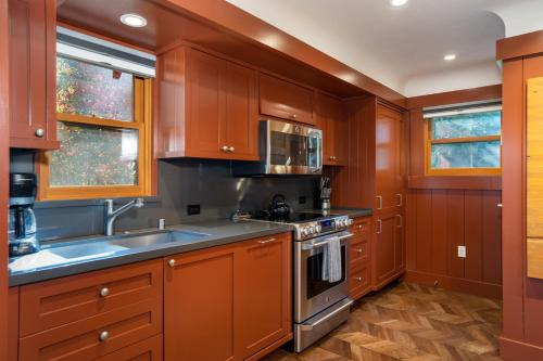 a kitchen with wooden cabinets and a stove top oven at Cedar Crest - Robin Cottage 6 in Homewood