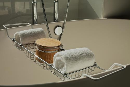 a sink with two towels and a jar in it at Kimpton Hotel Monaco Philadelphia, an IHG Hotel in Philadelphia