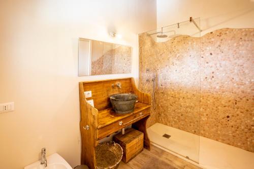 a bathroom with a wooden sink and a shower at Casa Stones B&B in Cugnana
