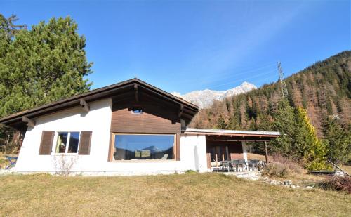 a house on a hill with mountains in the background at Haus Schwarz in Savognin