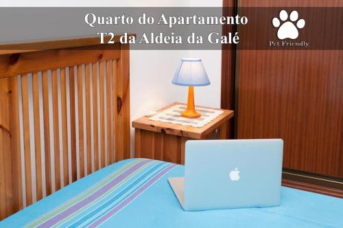 a laptop computer sitting on a bed with a lamp at Os Apartamentos A Ramos na Praia da Galé Estão inserido em Condomínio com PISCINA, Fica apenas a 350 Metros da Praia da Galé - Apartamentos com Ar Condicionado tanto nos Quartos como na Sala, Smart TV com Prime Vídeo e Cozinha Completa in Albufeira
