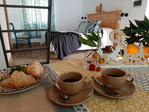 a table with two cups of coffee and croissants at Agriturismo Podere Bedin in San Felice Circeo