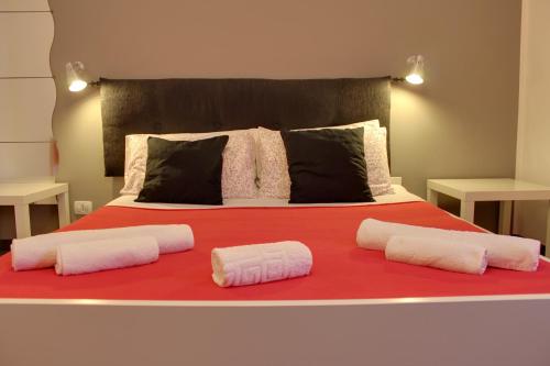a bed with two pillows on a red blanket at Anita & Garibaldi in Marsala