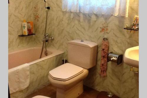 a bathroom with a toilet and a tub and a sink at Calella Playa in Calella