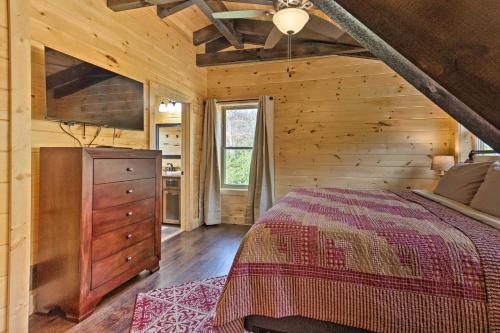 a bedroom with a bed in a wooden cabin at Hilltop Cabin on 5 Acres with Hot Tub and Waterfall! in Bryson City