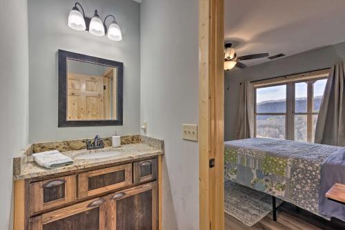 a bathroom with a sink and a bed and a window at Hilltop Cabin on 5 Acres with Hot Tub and Waterfall! in Bryson City