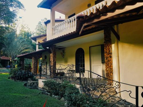 a house with a porch with chairs and a balcony at Tower Studio in the Treetops in Altos del Maria Panama in El Picacho