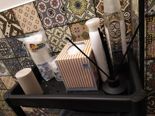 a black shelf with a box and toiletries on it at Апартаменти Світлий Ранок та Затишний Вечір in Rivne